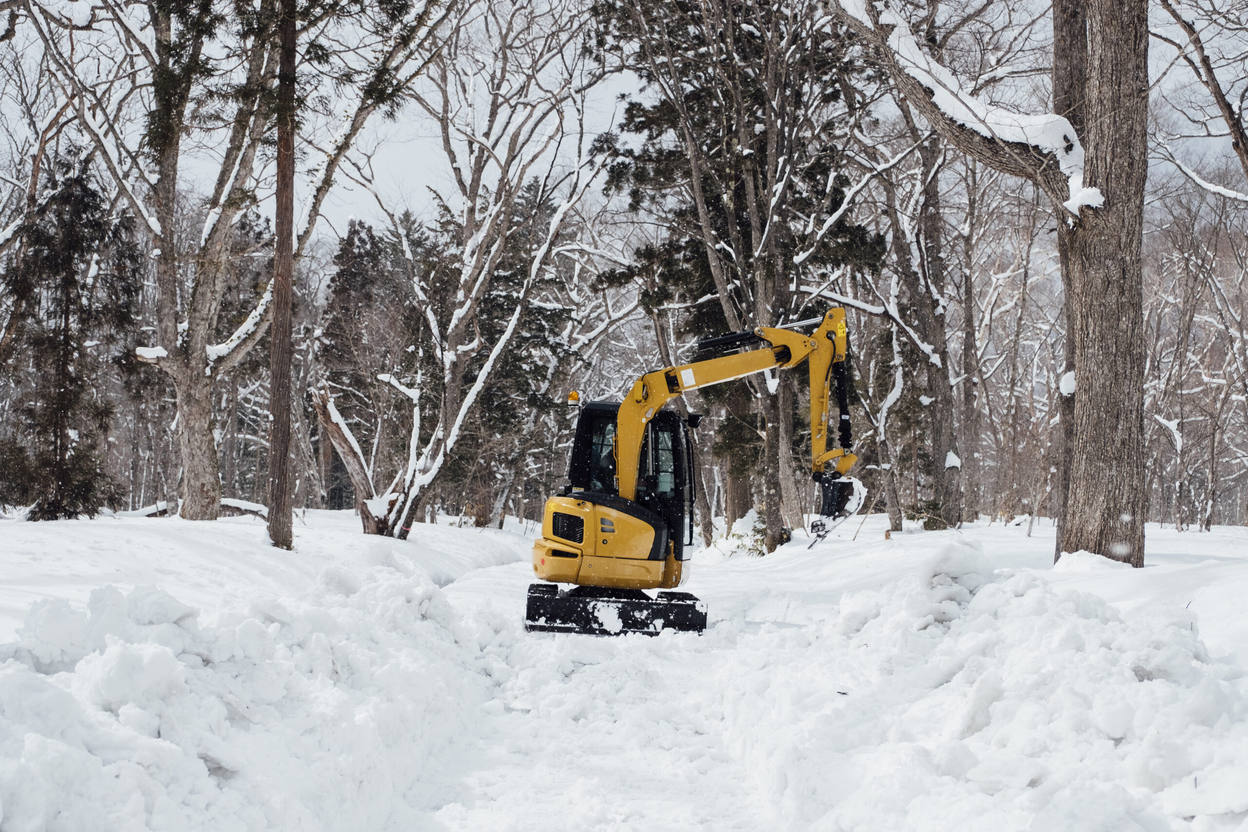 backhoe in snow at togakushi shrine, japan